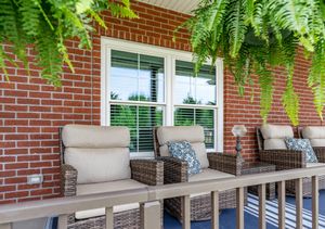 White double-hung windows with cottage grids on a residential porch