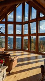 Floor-to-ceiling picture window wall in a log cabin great room with mountain views