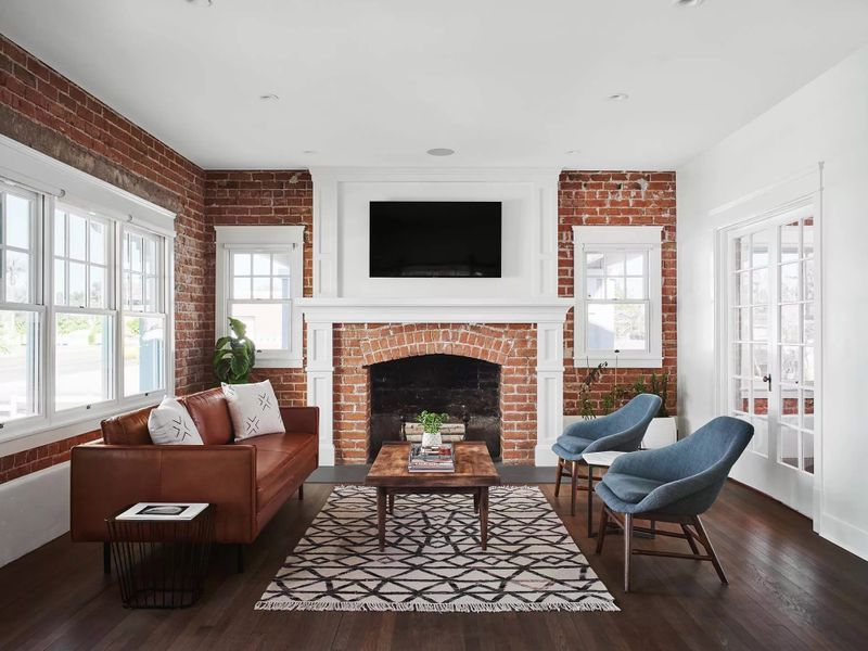 Traditional living room with brick wall and white-trimmed single-hung windows